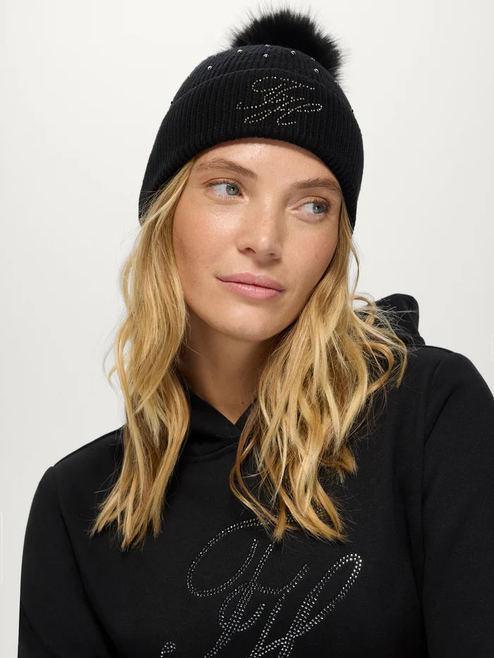 Woman wearing TH Daly Women Rhinestone Pom Pom Beanie in BLACK
